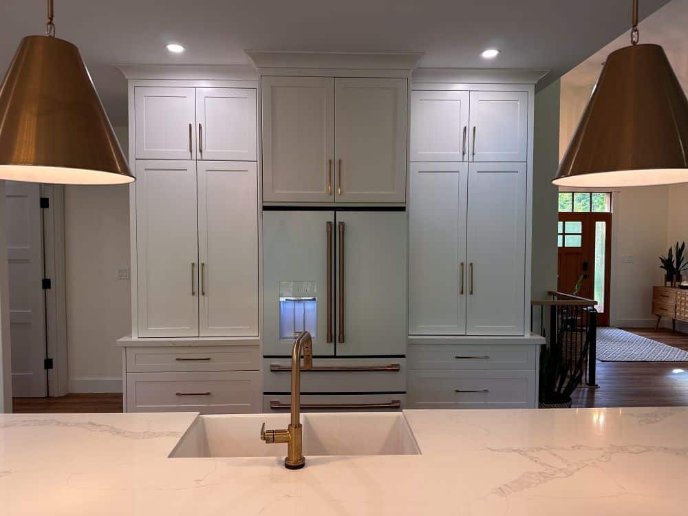 A kitchen with white cabinets and a sink.